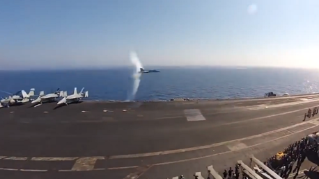 Un caza F/A-18C Hornet hace una espectacular pasada supersónica frente a un portaaviones
