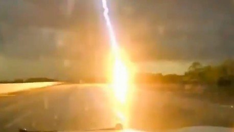 Un rayo cae a pocos metros de un coche policía en carrertera