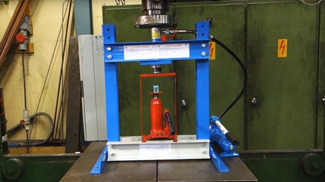 Una prensa hidráulica que aplasta a una prensa que aplasta a otra prensa