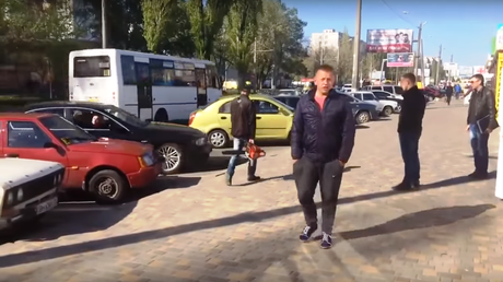 Surrealista: Atisbo de pelea, hombre con una sierra eléctrica y un auto en reversa fuera de control