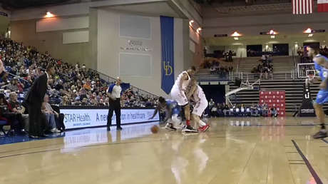 Baloncestista de 1,75 metros de altura se cuela entre las piernas de un rival durante un partido