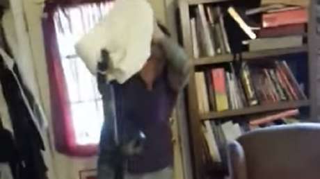 Una mujer atrapa una escurridiza serpiente con una funda de almohada