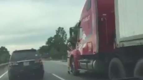 Impactante momento en que un policía agarrado a un camión es empotrado contra un muro