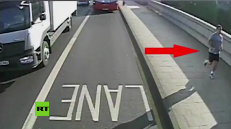 Un corredor empuja a una mujer a las ruedas de un autobús