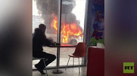 VIDEO: Un joven disfruta de un café a pocos pasos de un autobús en llamas