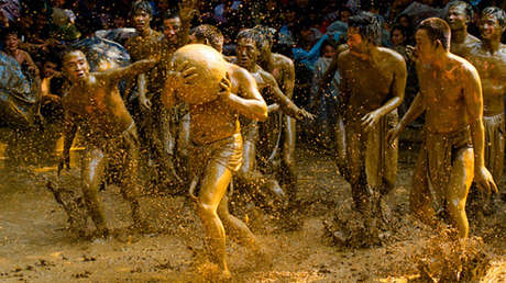 VIDEO: En taparrabos y cubiertos de lodo vietnamitas muestran su fuerza en una ancestral batalla