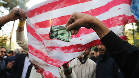 Manifestantes iraníes queman dólares y banderas de EE.UU. por la reanudación de las sanciones