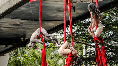 'Un país que siembra cuerpos': Artistas desnudos y colgados de un puente denuncian los asesinatos en Colombia