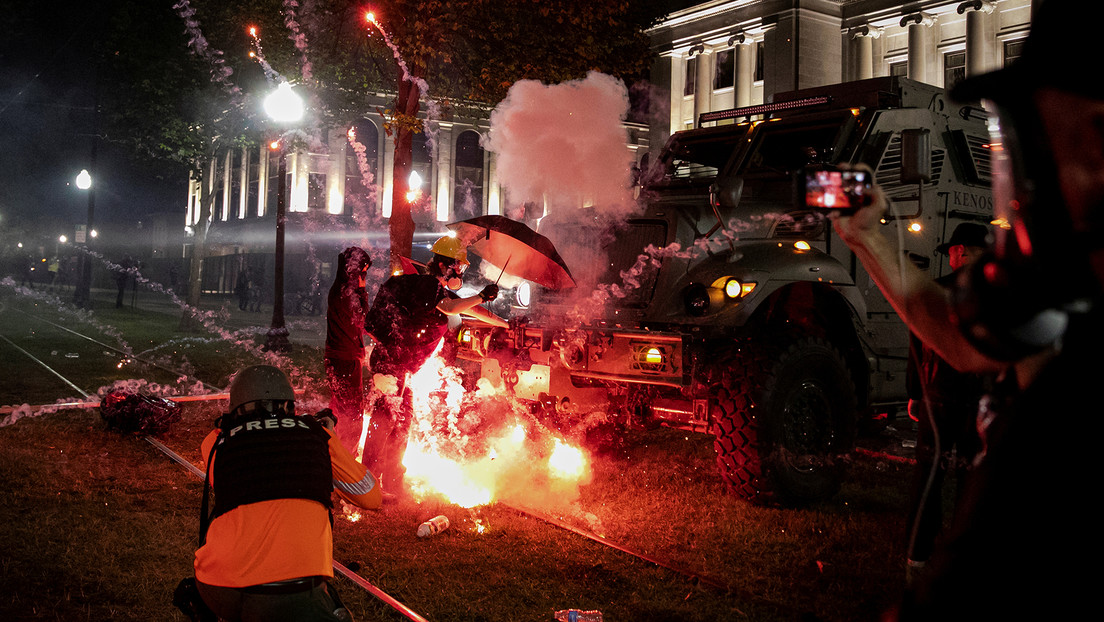 An incendiary device goes off in front of a Kenosha Country Sheriff Vehicle as demonstrators take part in a protest following the police shooting of Jacob Blake, a Black man, in Kenosha