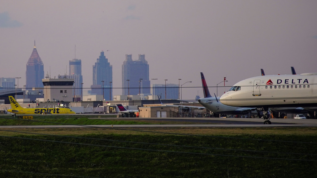 Una pareja y su perra saltan de un avión en movimiento tras activar el tobogán de emergencias en la pista de un aeropuerto en Nueva York