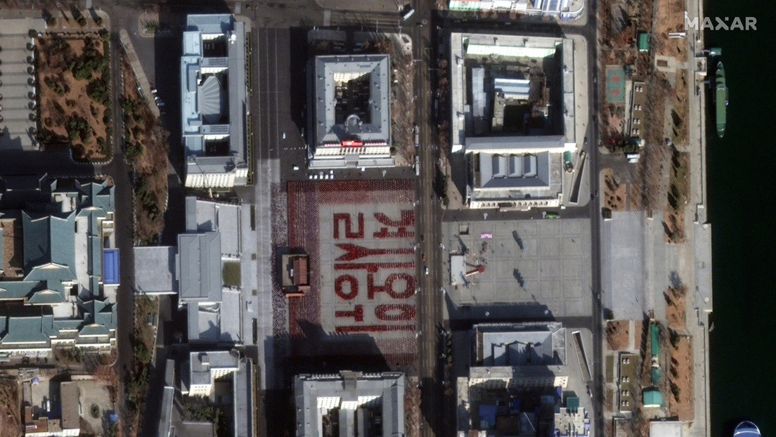 FOTO: Miles de norcoreanos crean con sus cuerpos la frase "defender con su vida" durante el ensayo de un desfile