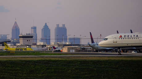 Una pareja y su perra saltan de un avión en movimiento tras activar el tobogán de emergencias en la pista de un aeropuerto en Nueva York