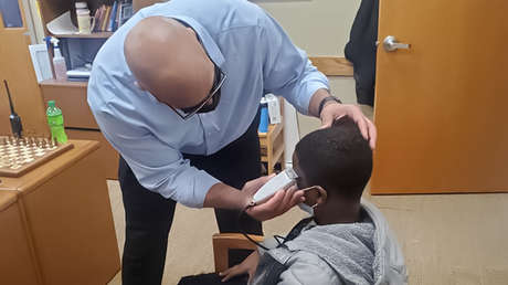 El director de una escuela le hace un corte de cabello a un estudiante que no quería entrar a clases por su apariencia
