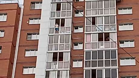 Un hombre trepa fuera de un balcón y amenaza con arrojar a un niño al vacío para exigir la presencia de su mujer