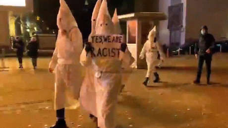 Graban a un grupo con trajes del Ku Klux Klan y pancartas "sí somos racistas" en la capital de Ucrania en Halloween