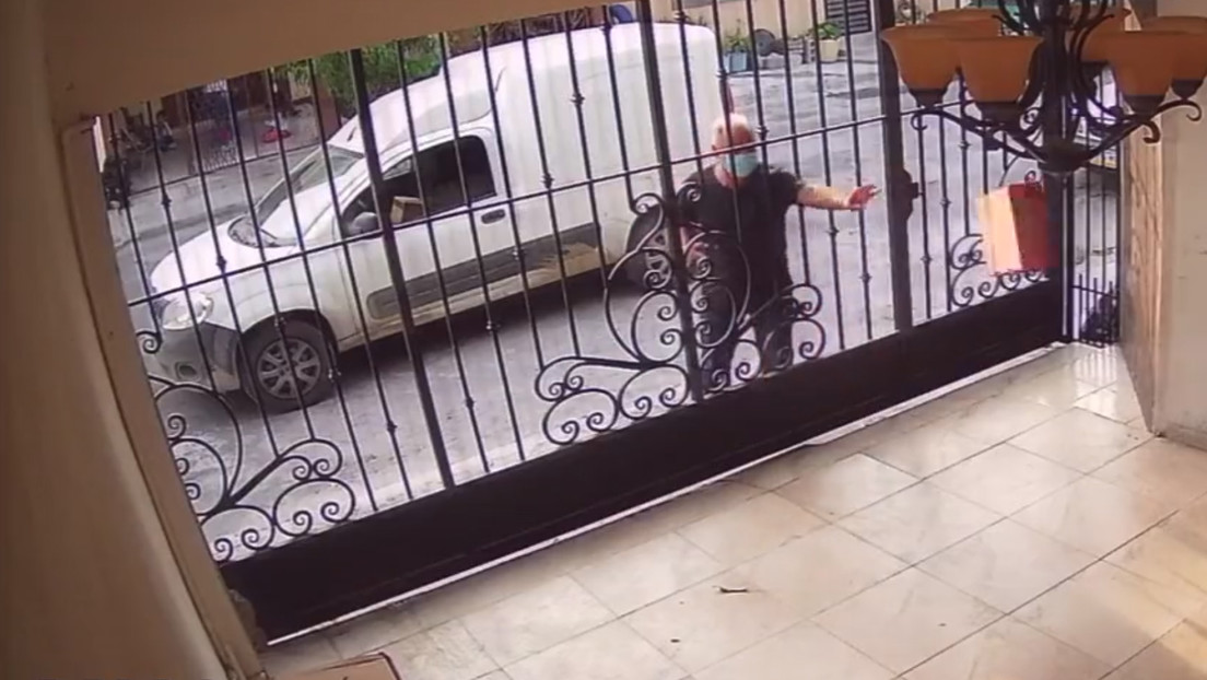 Graban a un repartidor lanzando por los aires un portátil a través de una verja en México