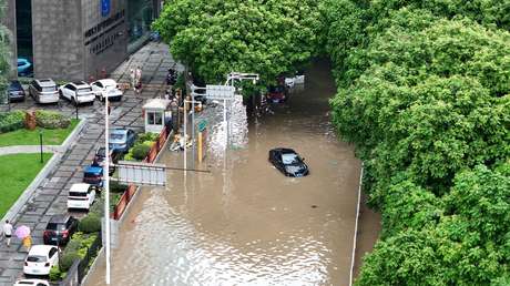 Habitantes de ciudades chinas caminan con el agua hasta el pecho durante fuertes lluvias (VIDEOS)
