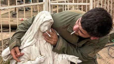 Soldado israelí coloca un cigarrillo en la boca de estatua de la Virgen María